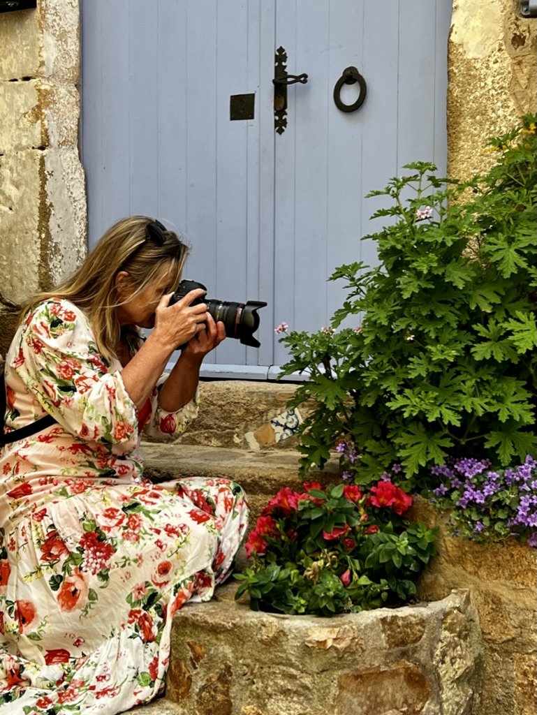 Helmy photographing flowers on a cobblestone step on the Costa Brava